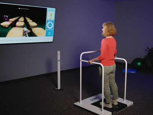 Patient playing therapeutic games on Alfa balance training equipment