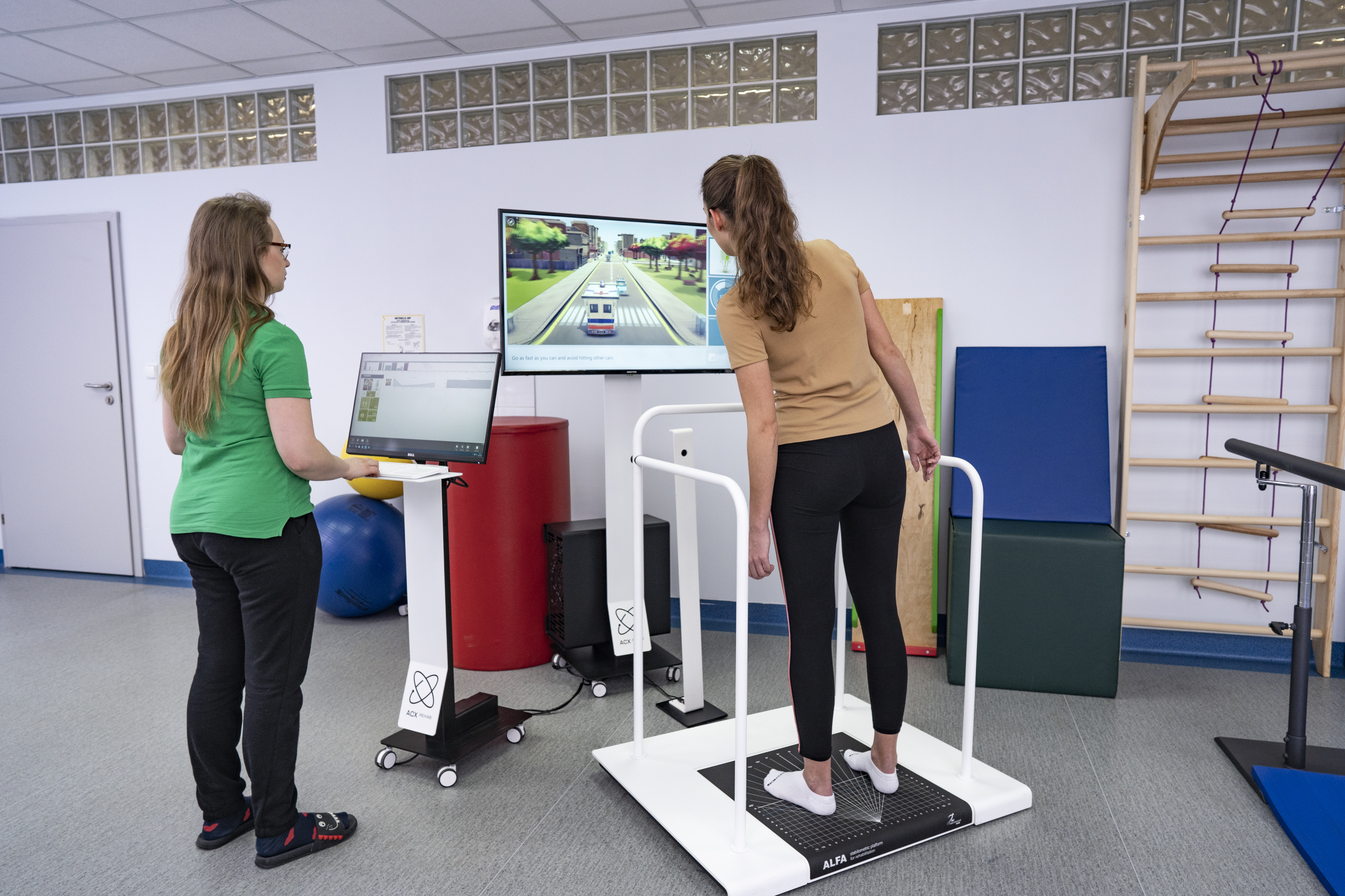 Clinician monitors as patient performs balance training exercise on Alfa