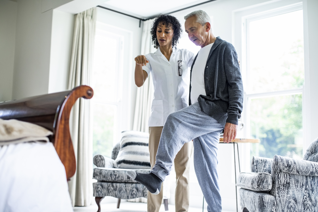 Clinician guides as patient balances on one leg